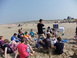 Guido van Belle aan het strand om les te geven over de stijging van de zeespiegel (foto aangeleverd)