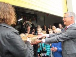 Het overhandigen van de mand met 5 broden en 2 vissen door wethouder Bert Fintelman